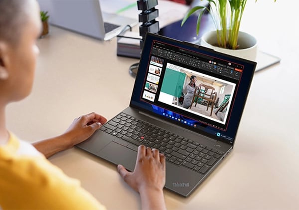 Person at a table, working on a slideshow on a Lenovo ThinkPad E16 (16